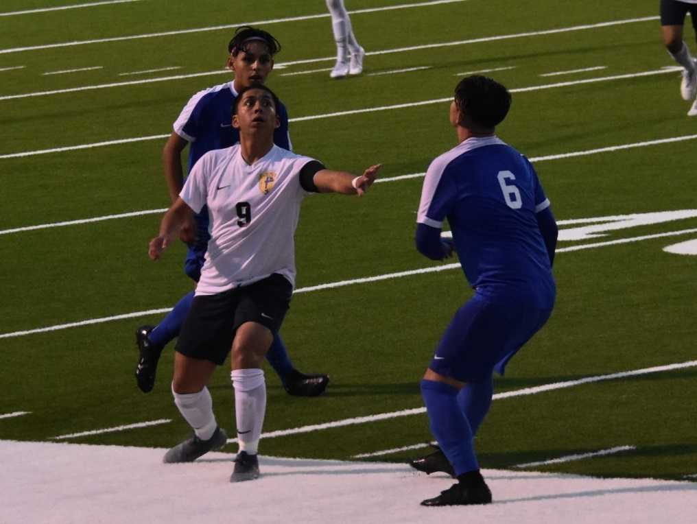 Stayton's David Ramirez (center) fights for possession against Woodburn. (Photo by Jeremy McDonald)