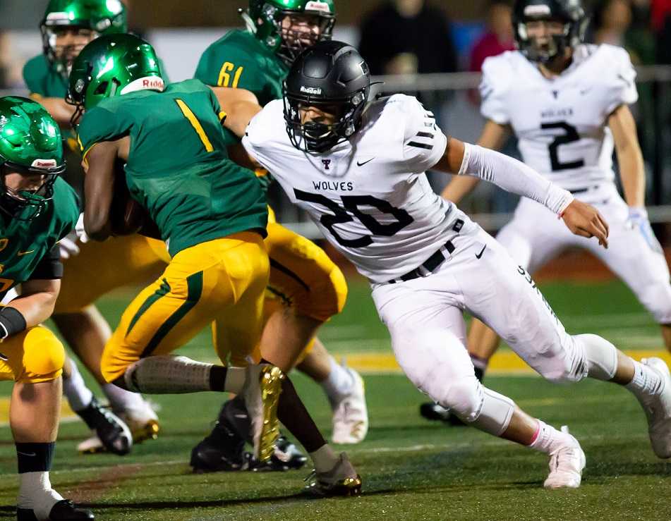 Oregon State-bound linebacker John Miller (20) helps lead Tualatin against Lake Oswego. (Photo by Brad Cantor)