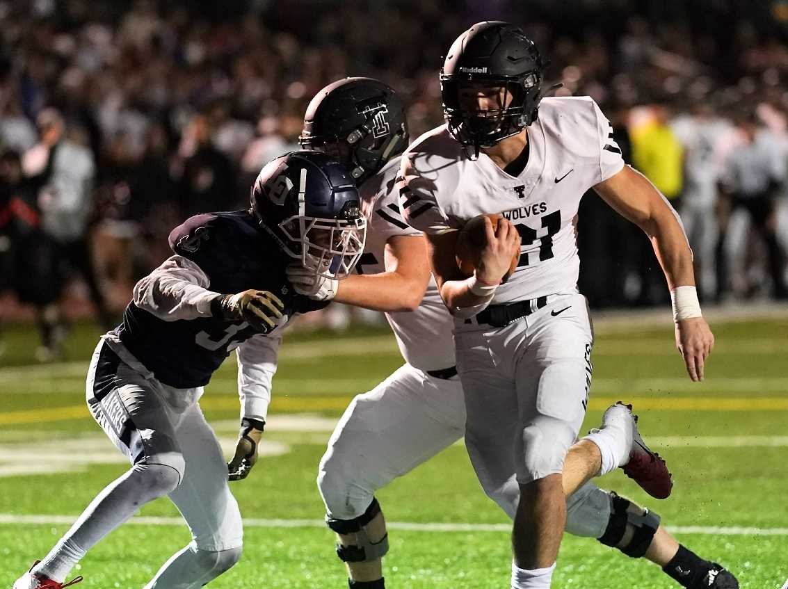 Tualatin's Kainoa Sayre runs for one of his three touchdowns Friday night. (Photo by Jon Olson)