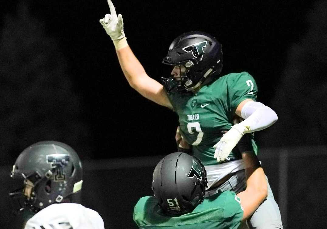 Tigard's Tyler Penn (2) celebrates with Edward Beglaryan after catching a touchdown pass Friday. (Photo by Jon Olson)