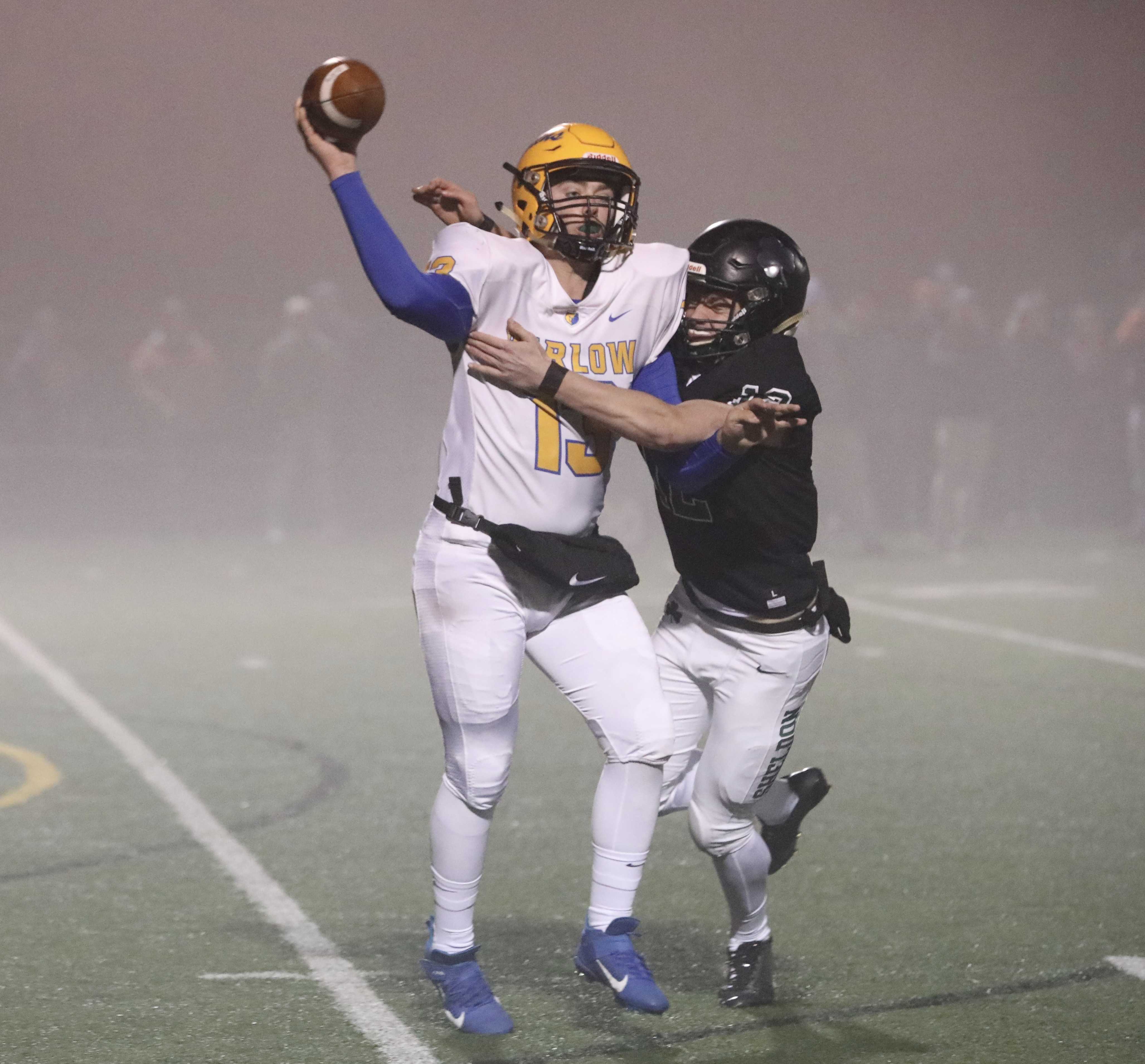 Barlow quarterback Jaren Hunter gets a pass off with Sheldon's Rhys Messner hanging onto him. (Photo by Norm Maves Jr.)