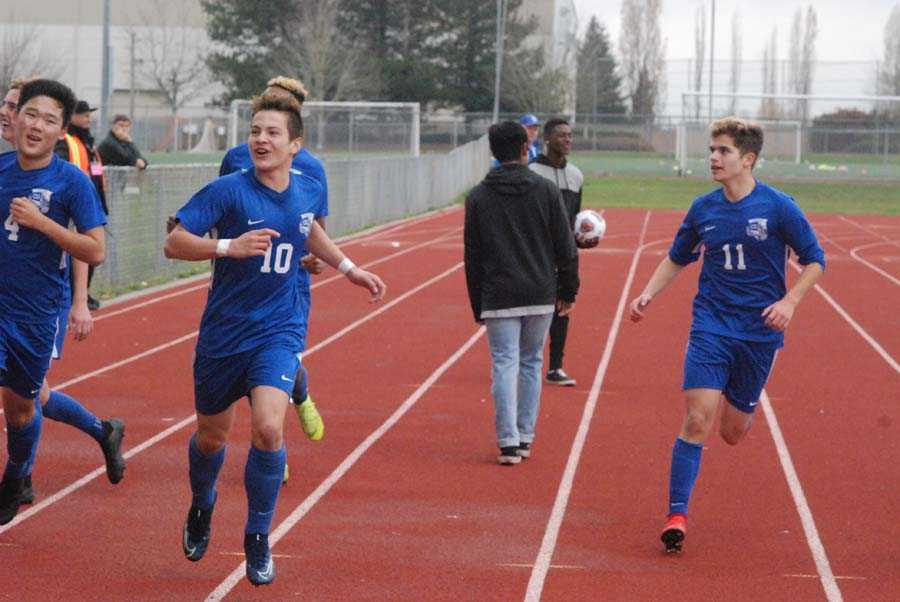 Felipe Rueda (10), flanked by Noah Kim (4) and Elijah Widdows, takes a victory lap after netting the insurance goal for CG