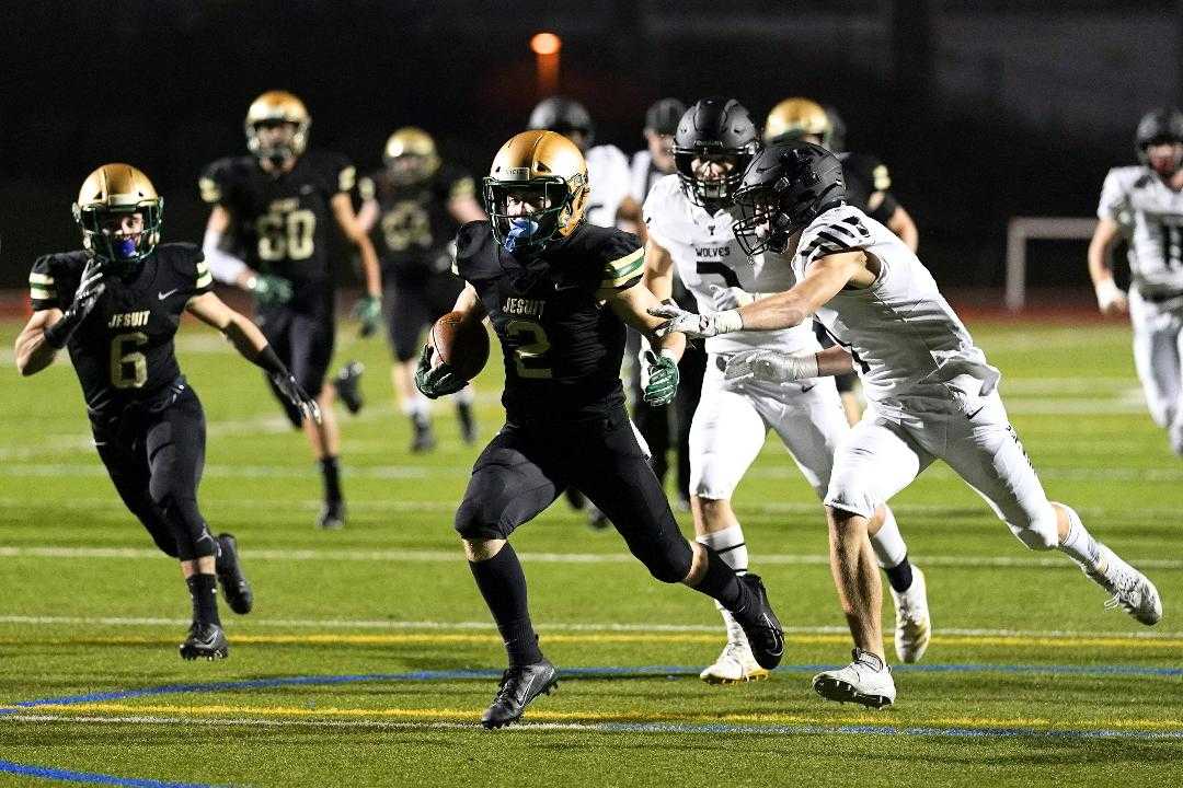 Jesuit's Kade Wisher eludes a defender on the way to one of his four touchdowns Friday night. (Photo by Jon Olson)