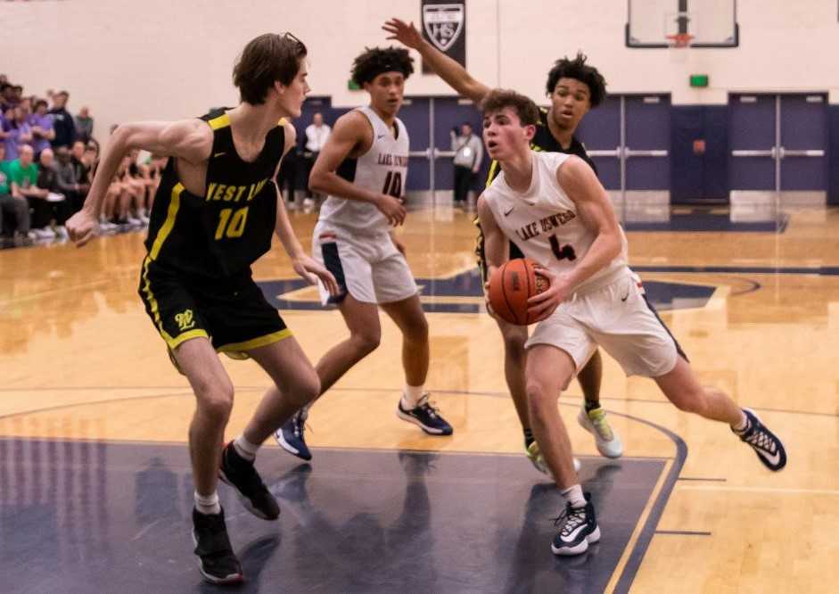 Lake Oswego's Jack Chlumak (4) drives toward West Linn's Mason VanBeenan (10). (Photo by Gene Schwartz)