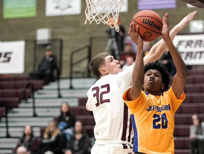 Jefferson's Jalen Adams (20) goes to the basket against Franklin's Trenton Rymal. (Photo by Jon Olson)