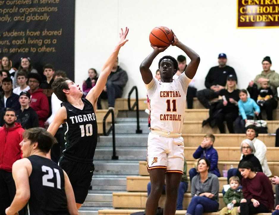 Central Catholic's Darius Gakwasi (11) shoots over Tigard's Jake Wihtol (10) on Saturday. (Photo by Jon Olson)