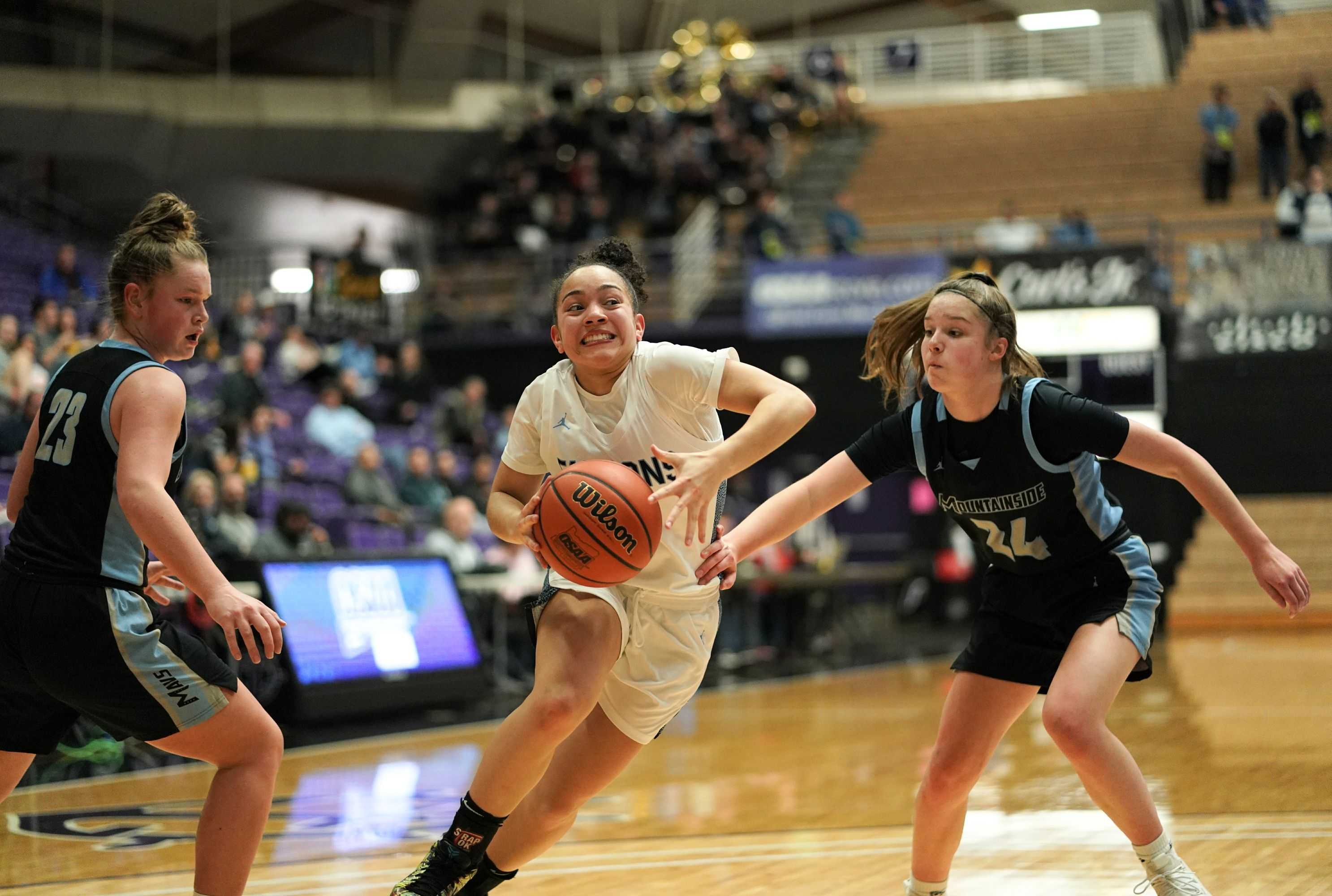 Liberty's Taylin Smith drives between Mountainside's Carly Stone (23) and Halle Hageman (24). (Photo by Jon Olson)