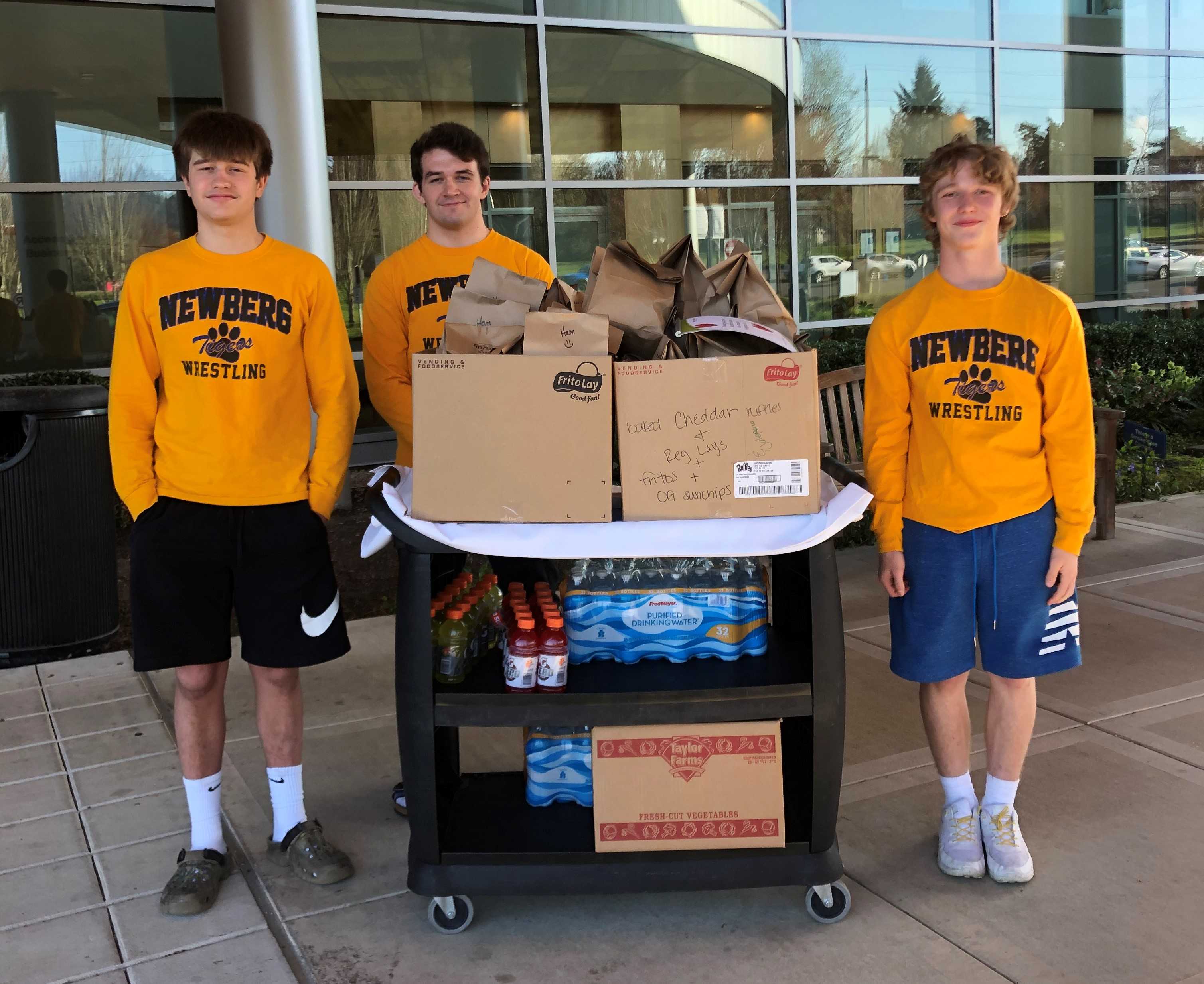 Newberg state champions (from left) Charlie Evans, Hunter James and Ayden Garver deliver meals to the hospital.