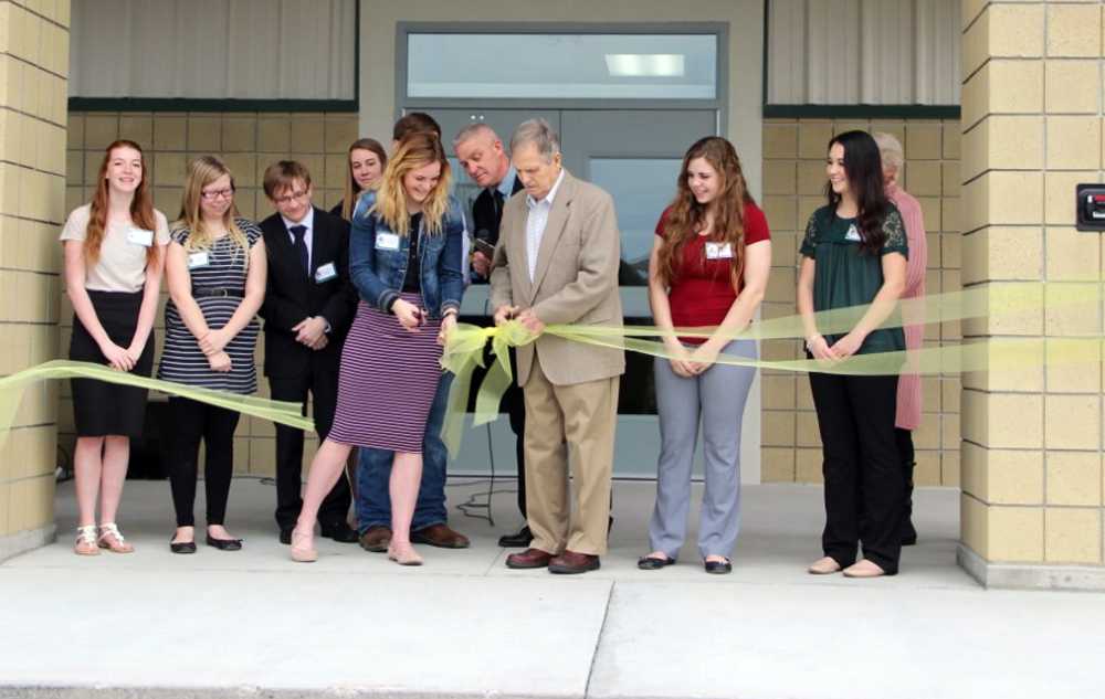 Gene Mills (center, in tan suit) presides over the dedication of the Adrian HS gym. Photo courtesy of the Argus Observer