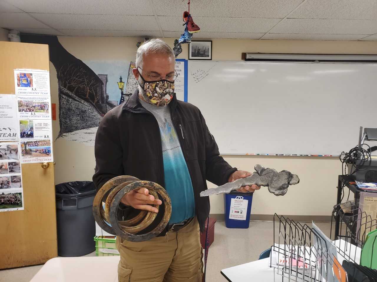 Phoenix track coach John Cornet holds discuses and a shot that were destroyed in the wildfires. (Photo courtesy Phoenix HS)