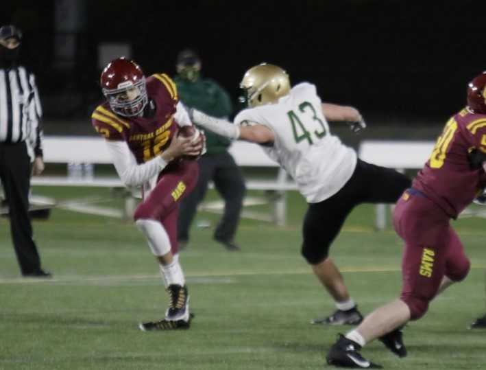 Central Catholic quarterback Luke Johnson avoids the rush of Jesuit's Spencer McKelligon. (Photo by Jim Nagae)