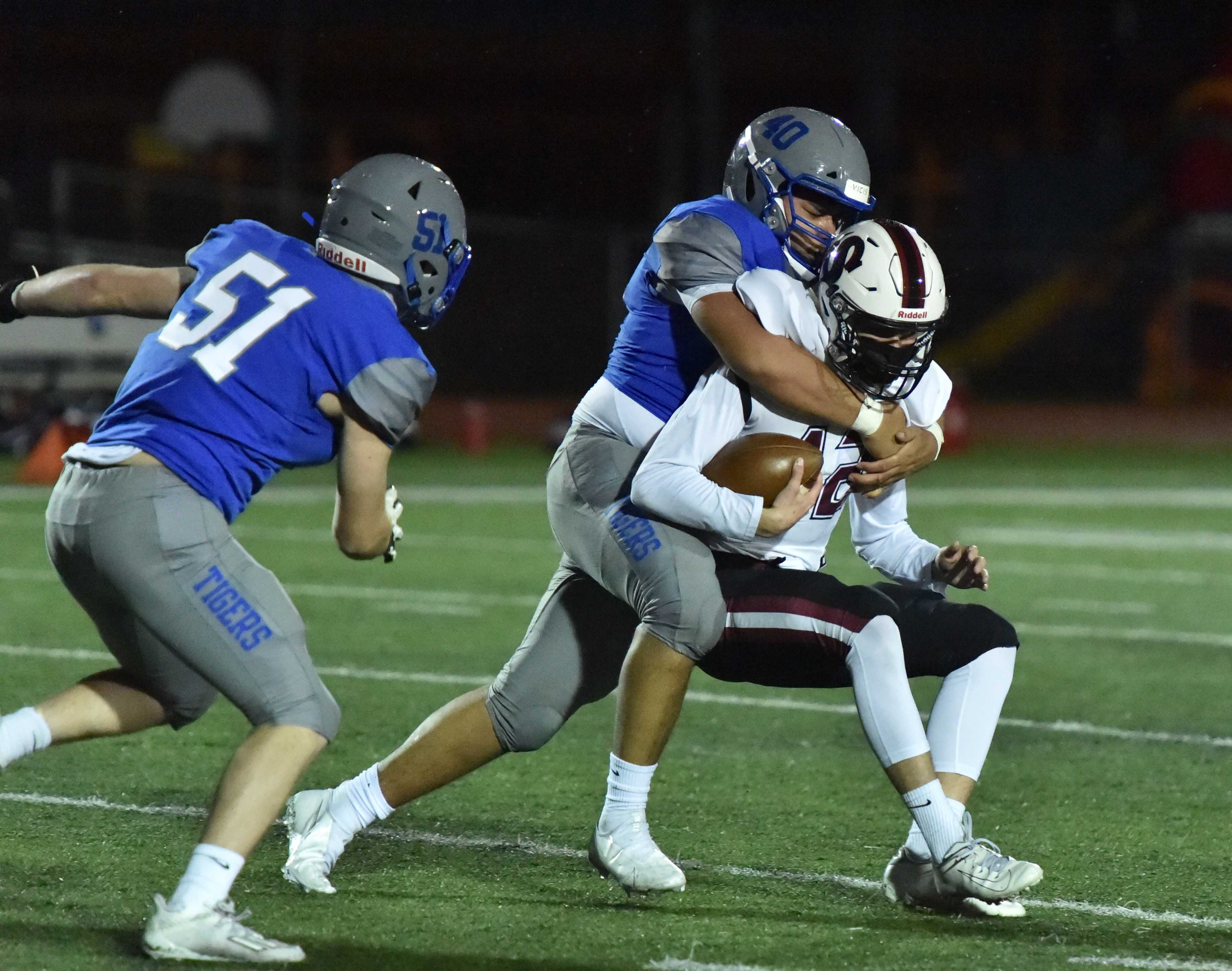 Newberg's Erik Vargas (40) and Mason Turpen (51) converge on Sherwood quarterback Bjorn Bergstrom. (Photo by Dean Takahashi)