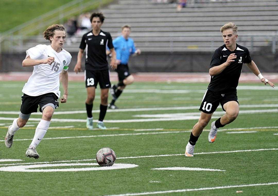 Summit's Nathaniel Deperro (15) works upfield against Jesuit's Spencer Carle (10) on Thursday. (Photo by Jon Olson)