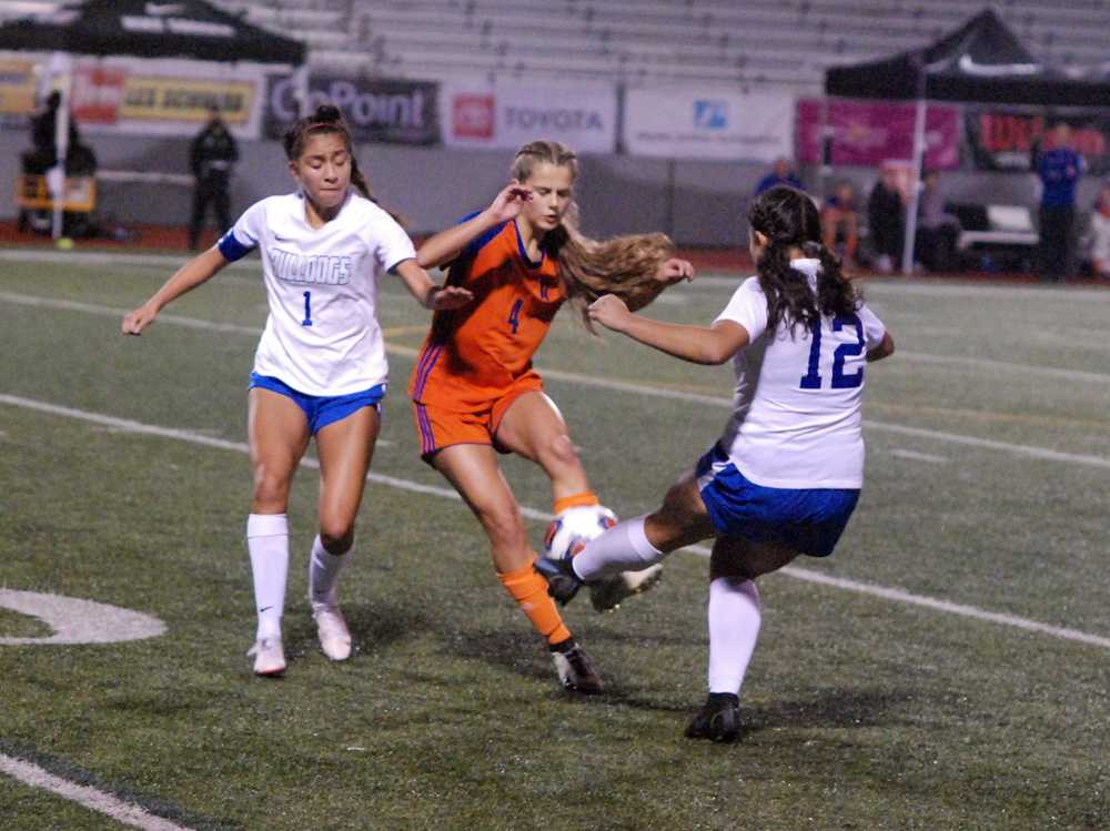 Hidden Valley midfielder Leah Beachy (4) is sandwiched by Woodburn players Myranda Marquez (1) and Julissa Rios