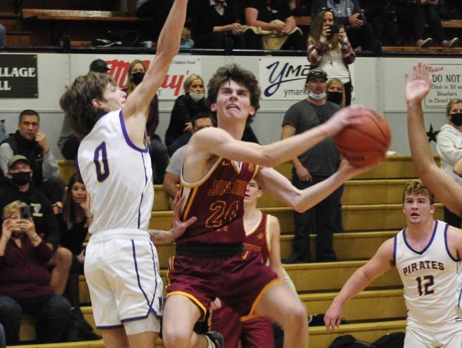 Junction City's Court Knabe drives to the basket against Marshfield's Mason Ainsworth on Friday night. (Photo by John Gunther)