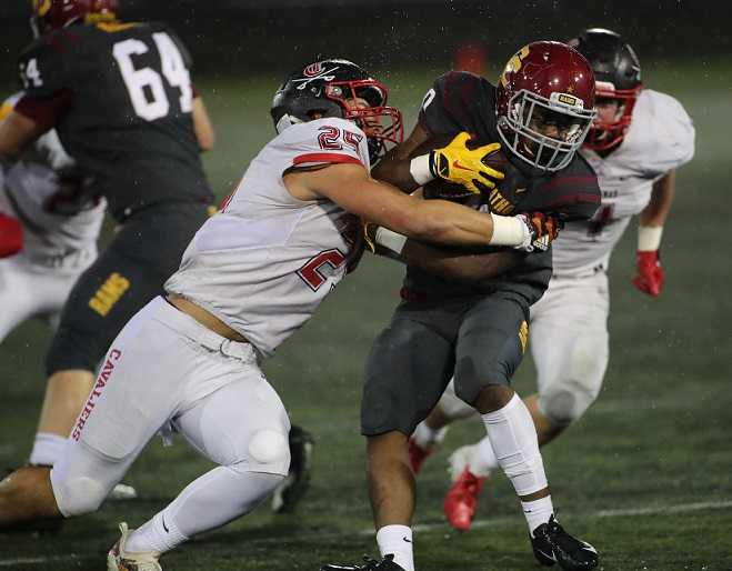 Clackamas' Justice Pagan wraps up Central Catholic's Elijah Elliott. (Photo courtesy Clackamas Touchdown Club)