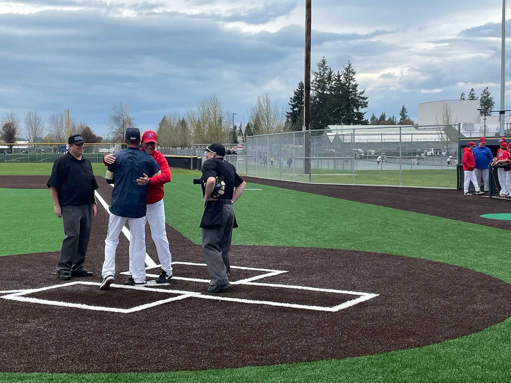 Lebanon coach Jeff Stolsig (in red) embraces son J.J., the coach at Canby, before a game earlier this year.