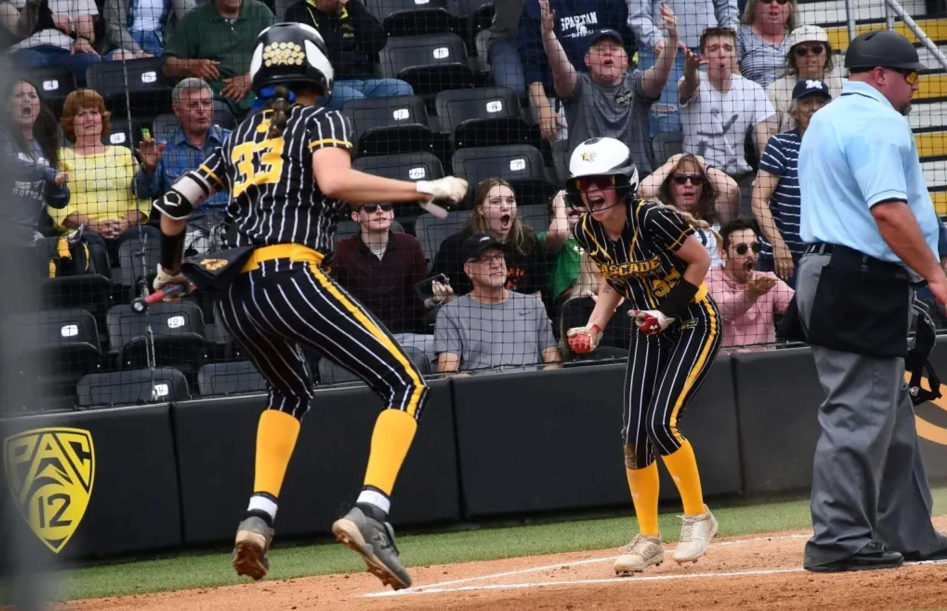 Cascade's Kailee Bode (right) celebrates with Hannah Walliman after scoring in the sixth inning. (Photo by Jeremy McDonald)