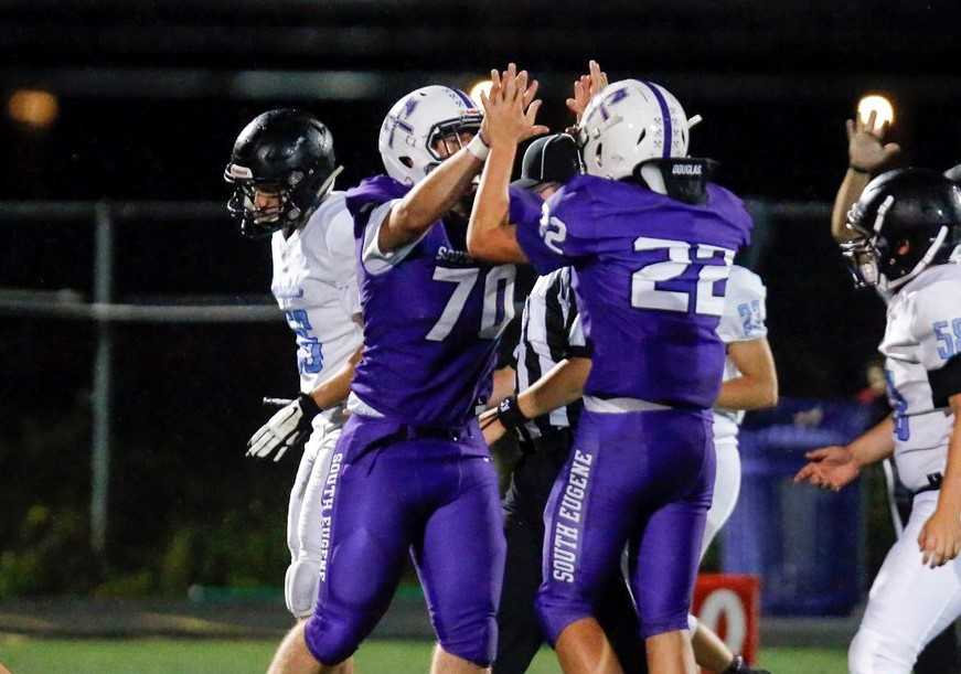 South Eugene's Joelie McKinley (70) and Austin Mills (22) celebrate a tackle during the 2019 season. (Courtesy photo)