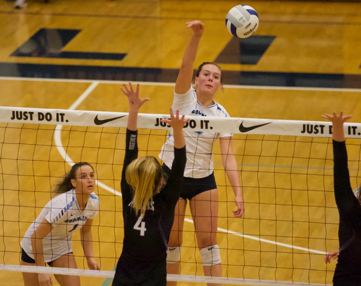 Corvallis' Ryann Gregg hits against Ridgeview's block Saturday night. (Photo by Norm Maves Jr.)