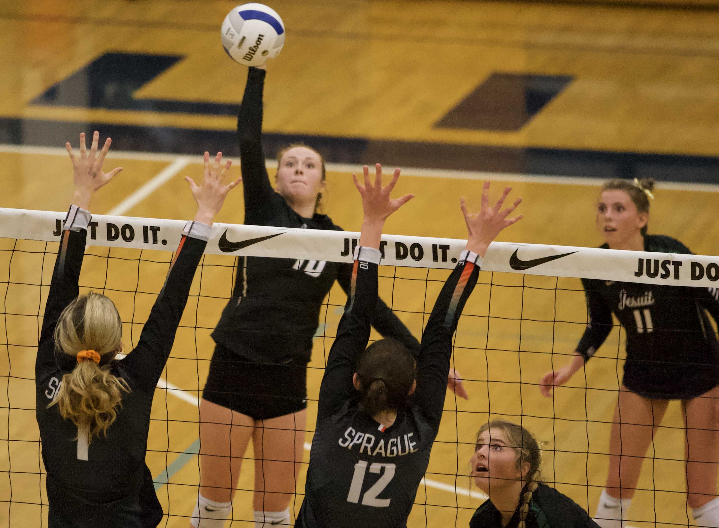 Jesuit's Brooke Olson blasts a smash through a late Sprague block. (Photo by Norm Maves Jr.)