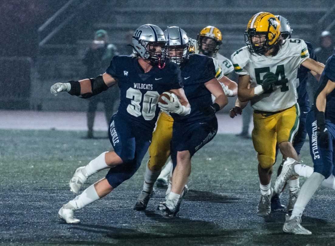 Wisonville's Jacob Ogden (30) runs away from Putnam's Oaklund Selfors (54) on Friday night. (Photo by Greg Artman)