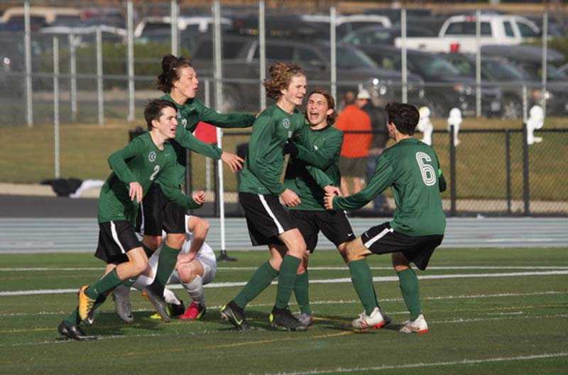 Kyle Capdevila celebrates with his Summit teammates after scoring the loan goal in the Storm's 1-0 overtime win