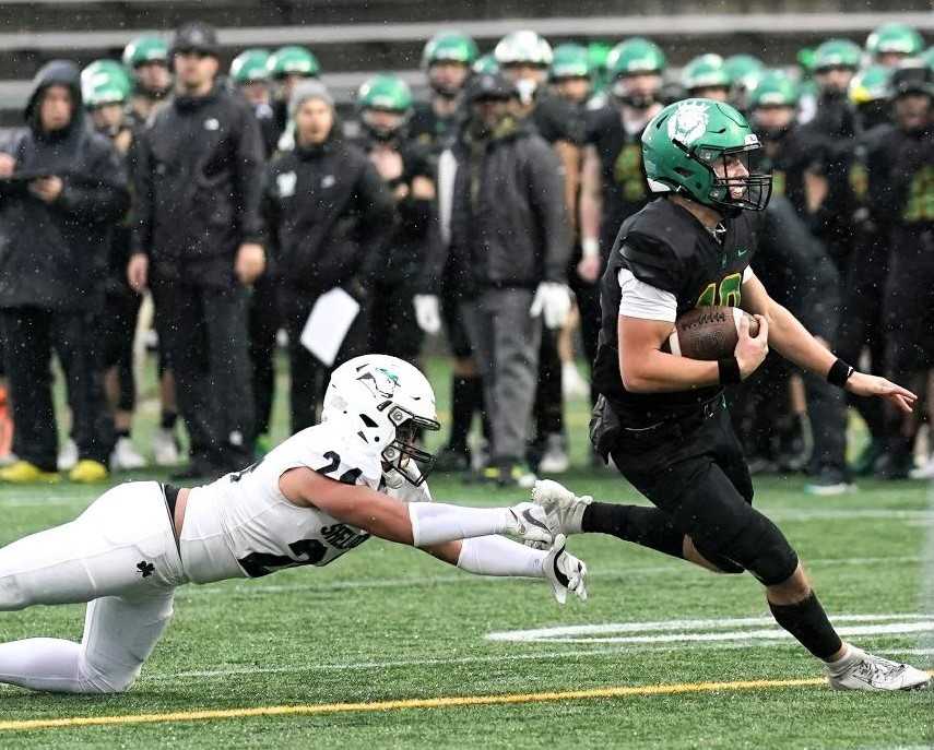 West Linn quarterback Sam Leavitt eludes the grasp of Sheldon's Mana Tuioti in Friday's 6A final. (Photo by Jon Olson)