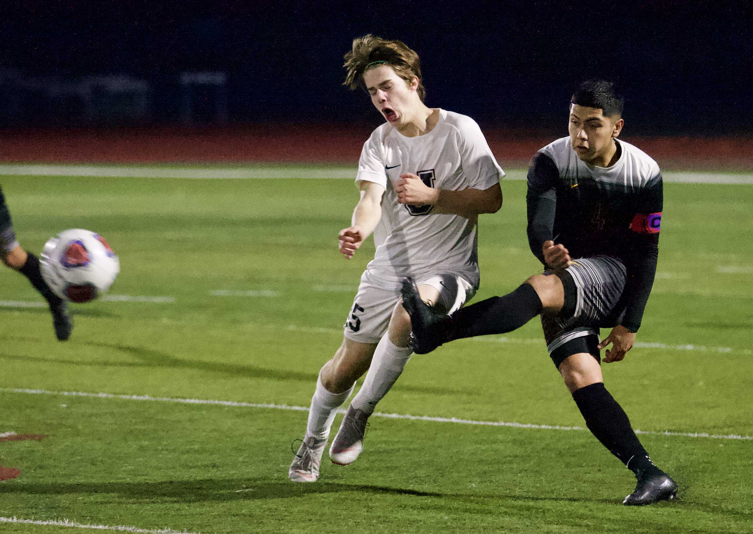 Forest Grove's Alejandro Sanchez (right) fires the ball downfield, past Jesuit's Rylie Acker. (Photo by Norm Maves Jr.)