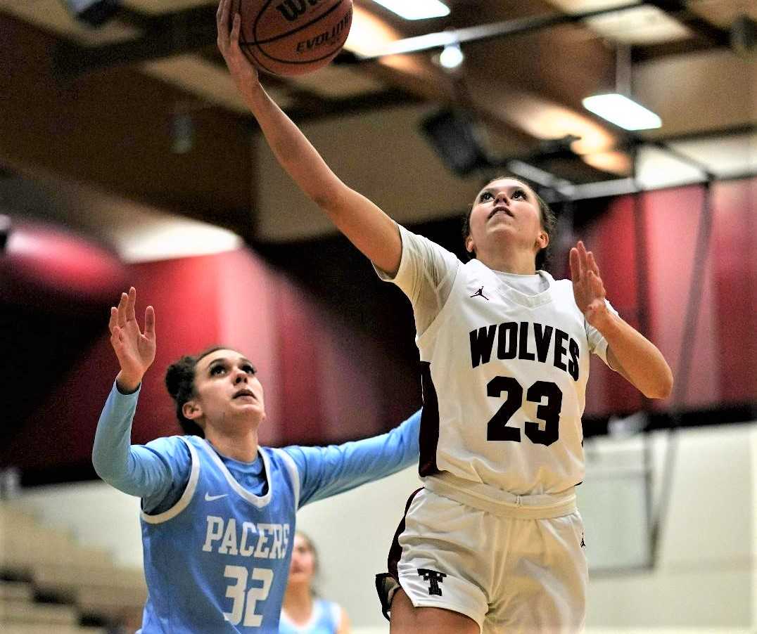 Tualatin's Tabi Searle (23) drives to the basket against Lakeridge's Jadyn Harrell (32) on Tuesday night. (Photo by Jon Olson)