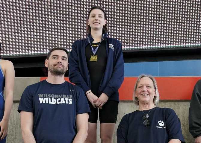 Wilsonville senior Helena Jones (center), with Wildcats coaches Brett Rodgers and Deb Mandeville. (Photo by Jon Olson)