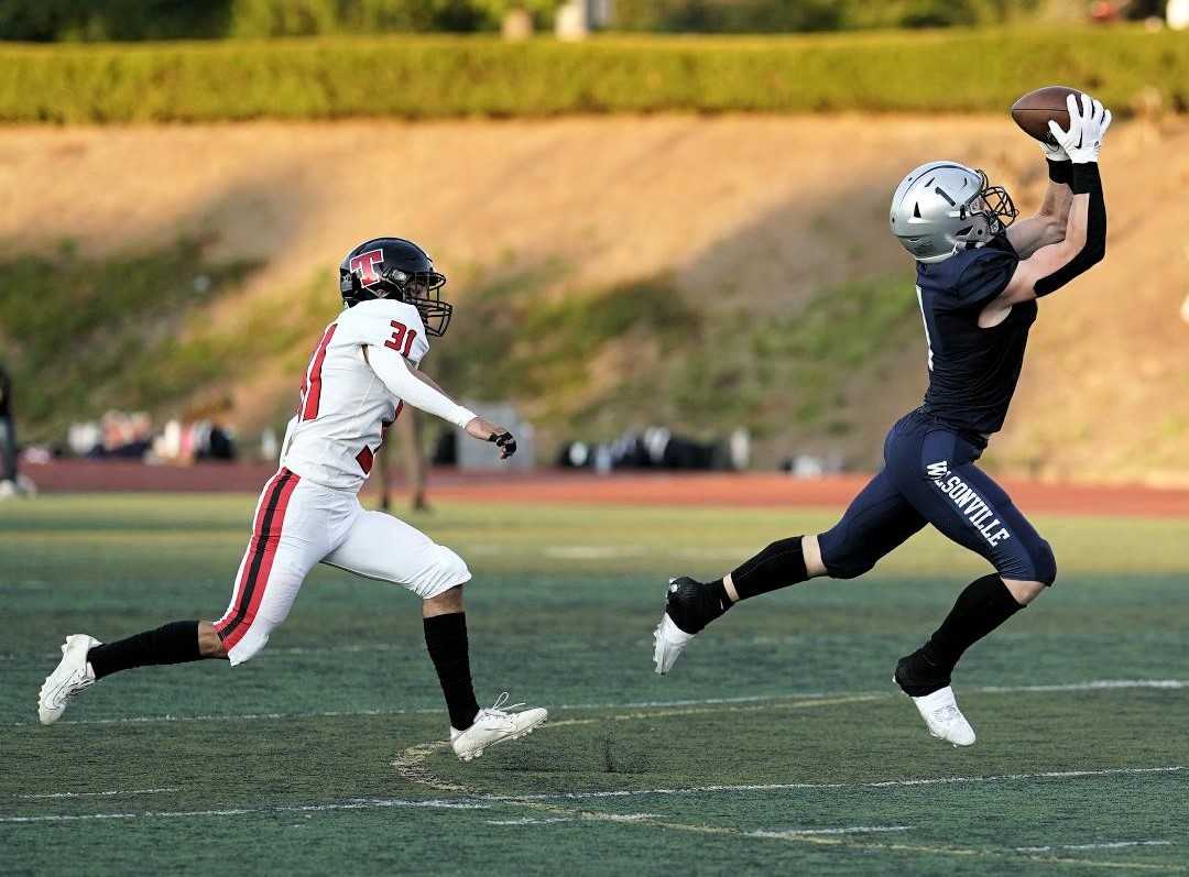 Wilsonville's Mark Wiepert hauls in a pass against Thurston's Holton Halstead in Friday's nonleague game. (Photo by Jon Olson)