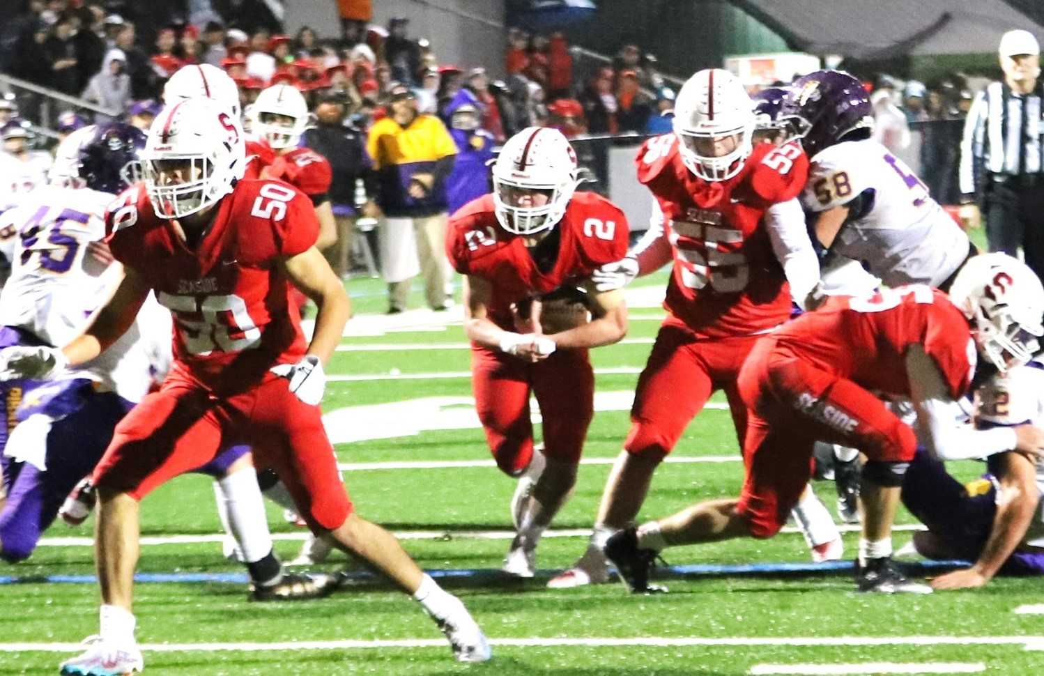 Seaside's Jake White (2) cuts through Marshfield's defense in a 14-6 quarterfinal win Friday. (Photo by Jeff TerHar)