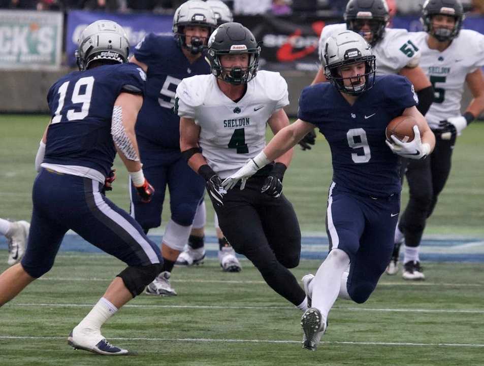 Lake Oswego's Casey Filkins (9) escapes Sheldon's Matthew Burgess (4) on a 40-yard touchdown catch. (Photo by Norm Maves Jr.)