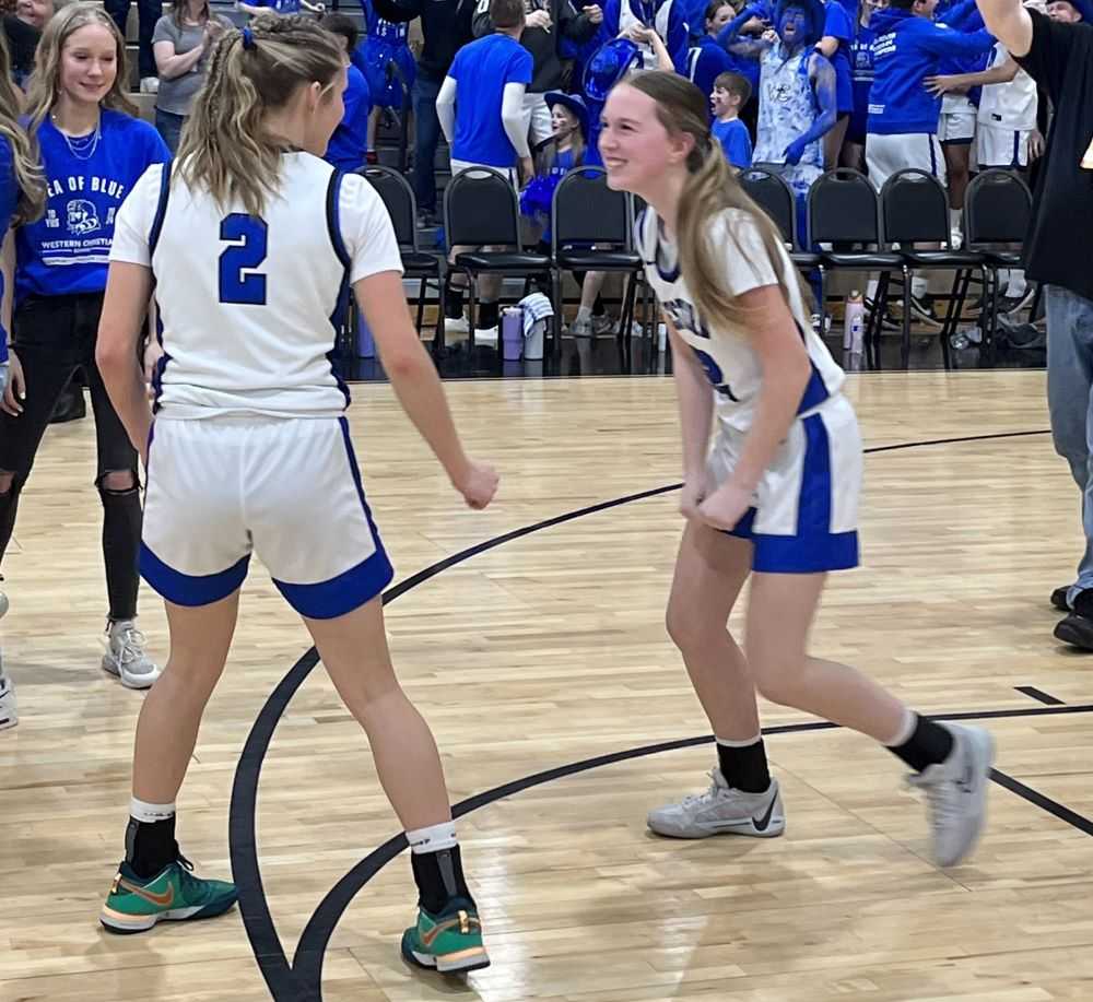 Haley Miersma (2) and Kinsale Wark (22) prepare for a state champion's bear hug after Western Christian's state title win