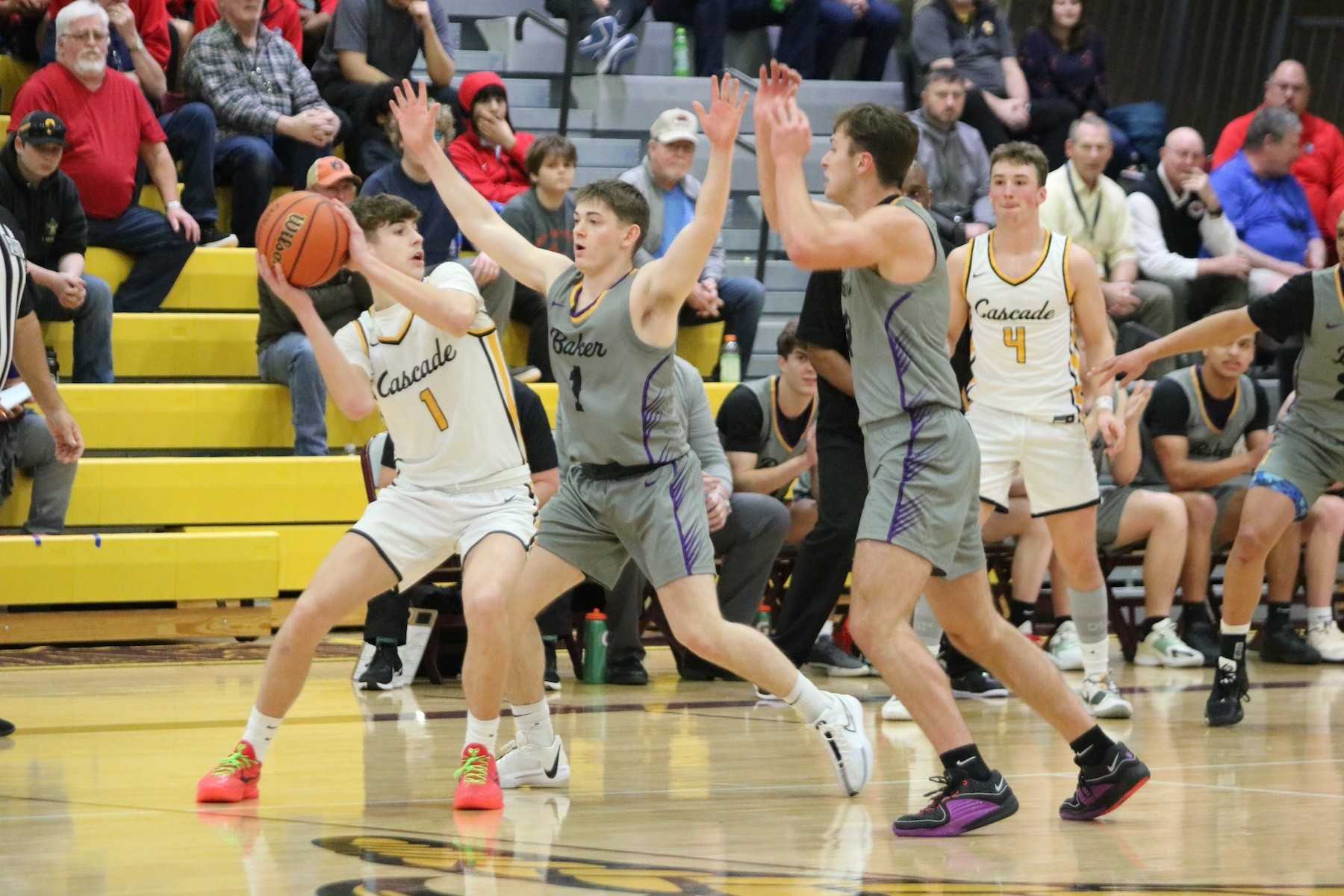 Cascade's Kaiden Ford (left) meets resistance Friday from Baker defenders Grant Gambleton and Paul Hobson. (Photo by Jim Beseda)