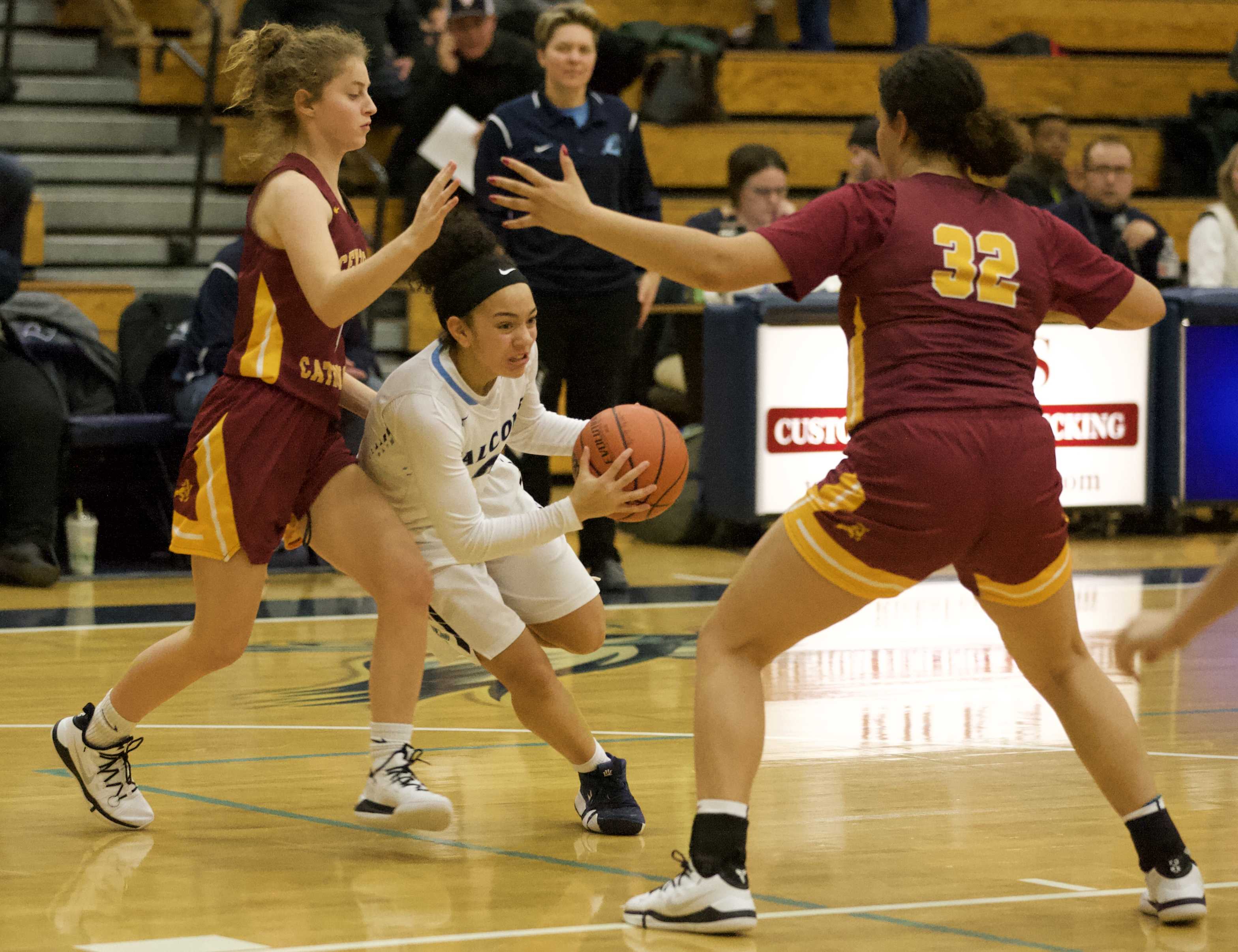 Liberty's Taylin Smith slices between Maylani Montgomery, left, and Bella Scarlett of Central Catholic.