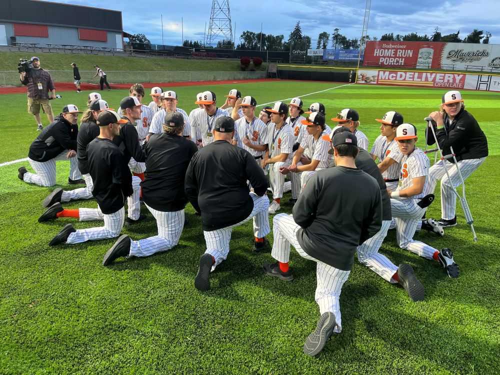 Scappose coach Cameron Webb (fourth coach from left) talks to his charges after repeating as 4A champions