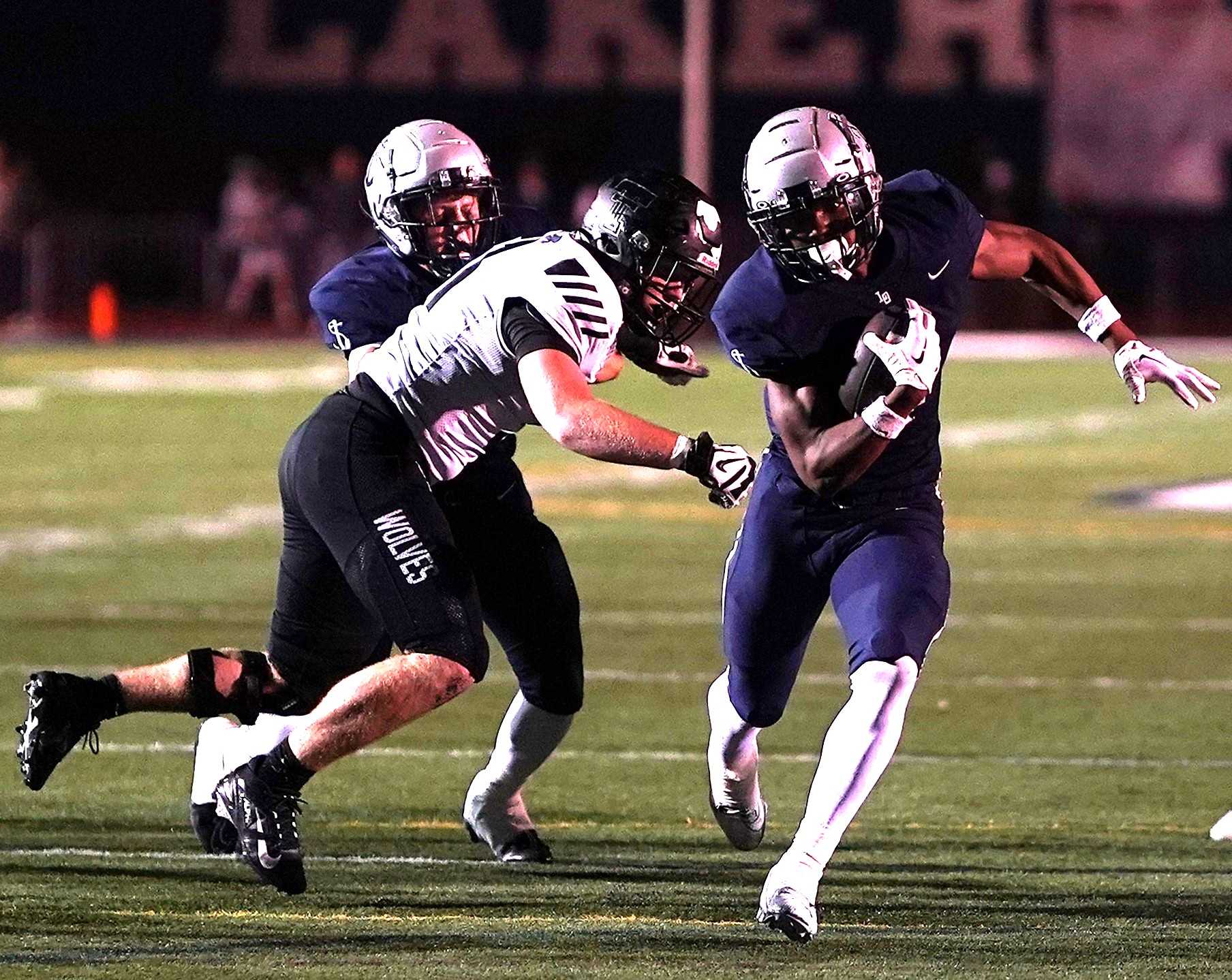 Lake Oswego's LaMarcus Bell evades a Tualatin defender on his way to one of his three touchdowns Friday. (Photo by J.R. Olson)