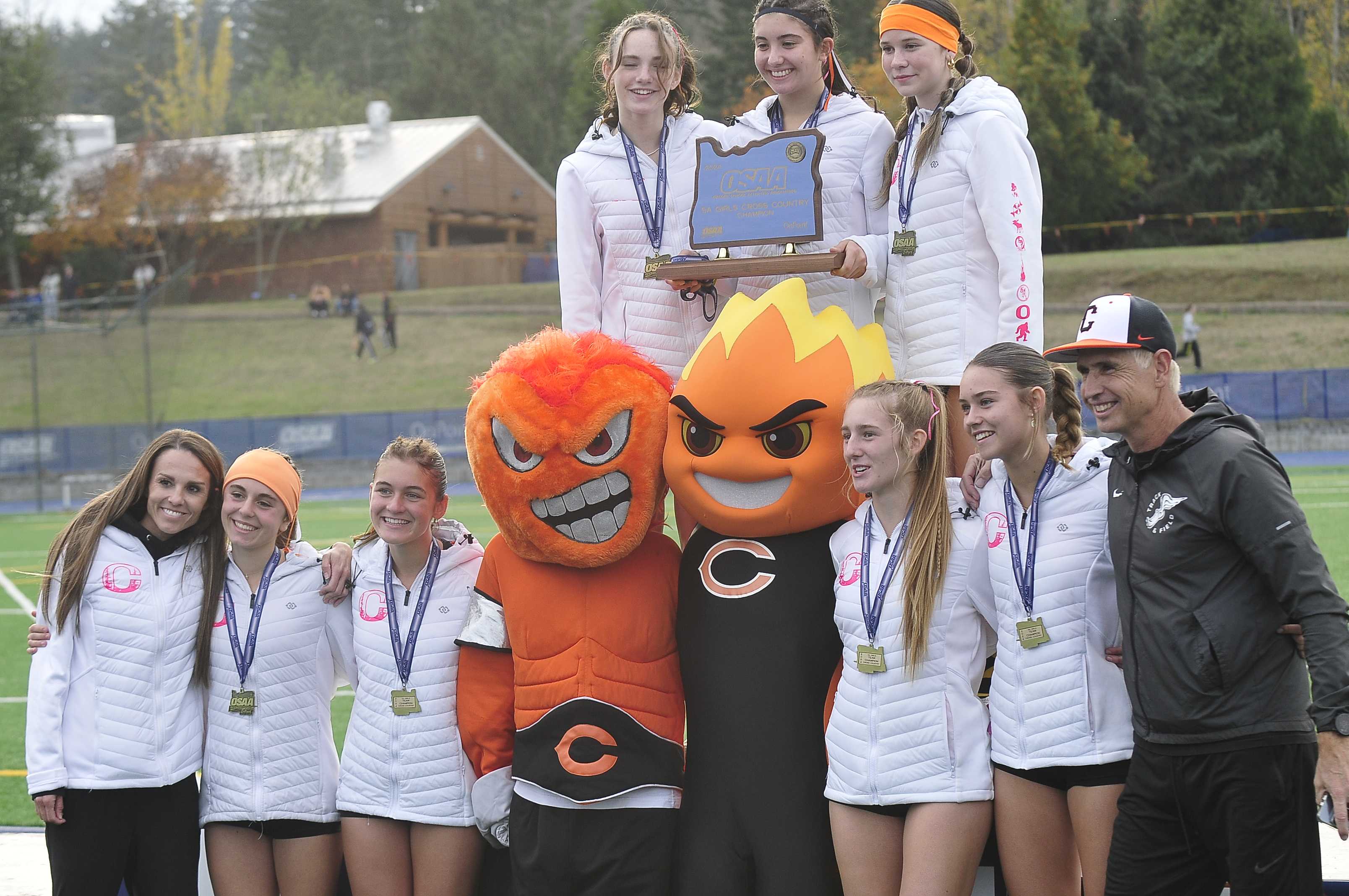 Crater's girls celebrate their state title with the school's mascots Saturday. (Photo by John Gunther)