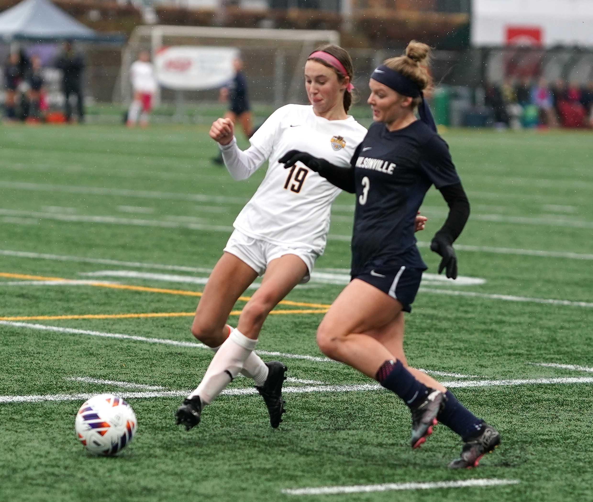 Wilsonville's Camryn Schaan (3) attacks against the defense of Bend's Isla Beall (19) on Saturday. (Photo by J.R. Olson)