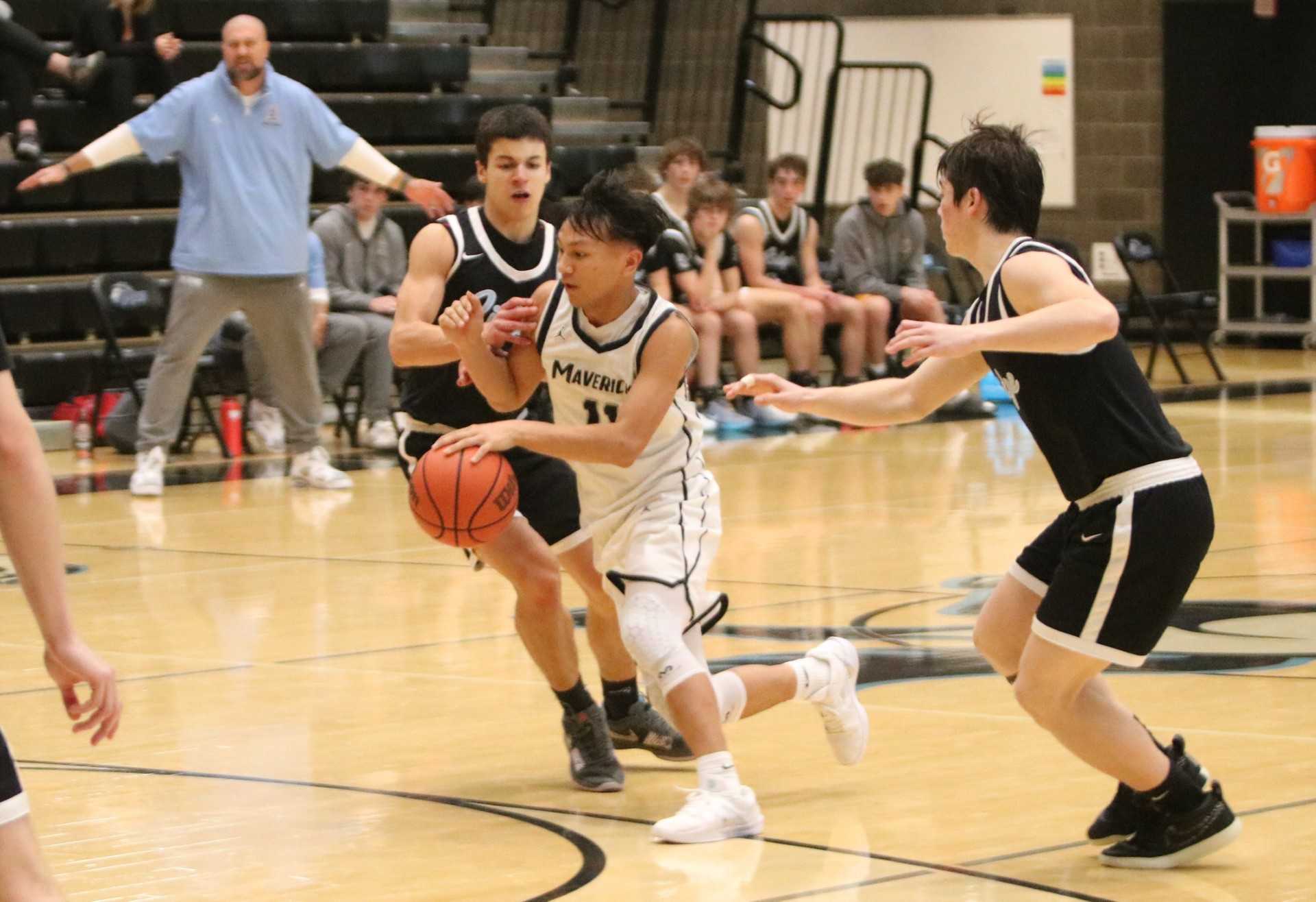 Mountainside's Peyton Reyes splits Lakeridge defenders Milo Harris and Micah Leake during Saturday's tournament action.