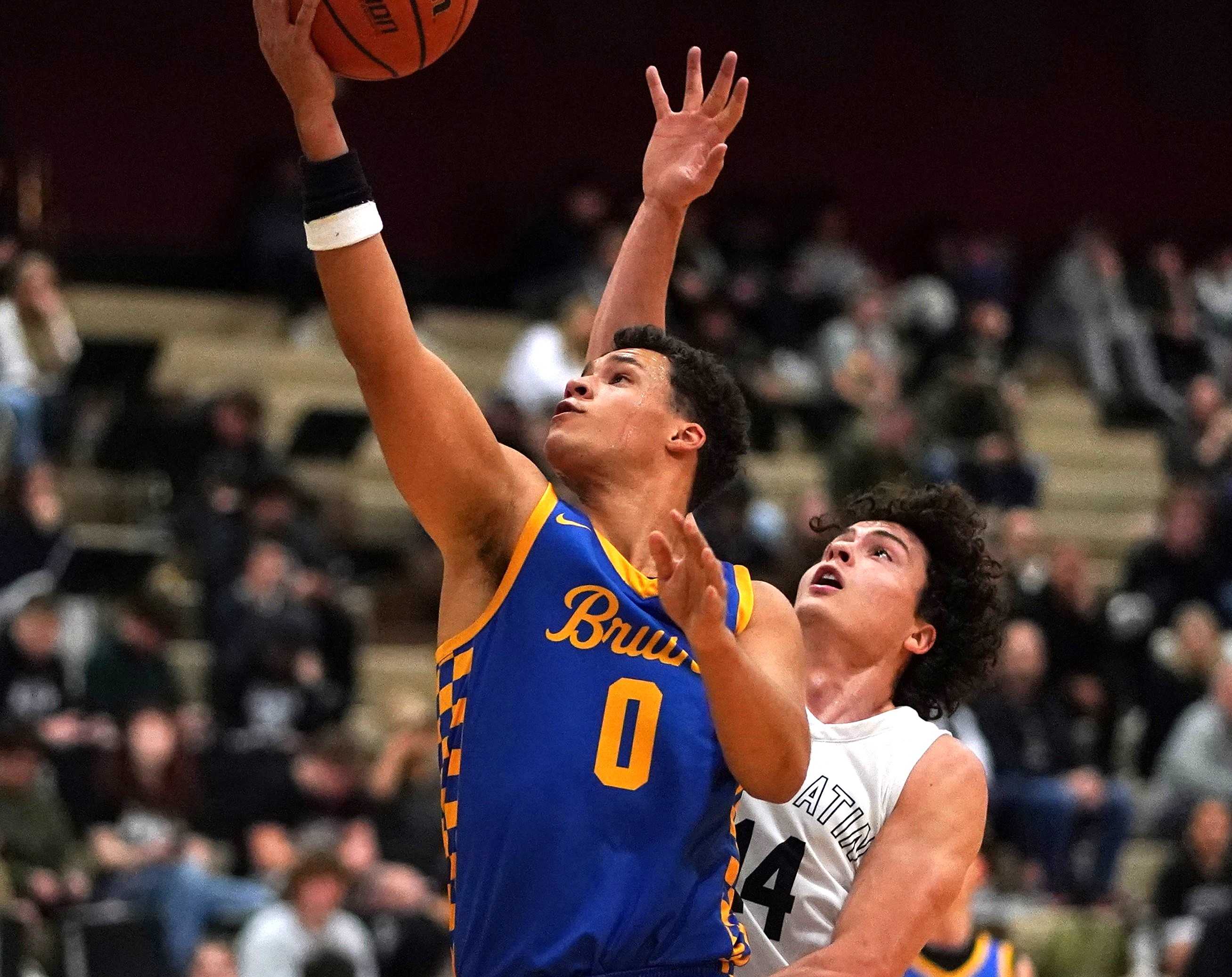 Barlow's Jalen Atkins (0) drives to the basket against Tualatin's Diogo Alves (14) on Thursday night. (Photo by J.R. Olson)