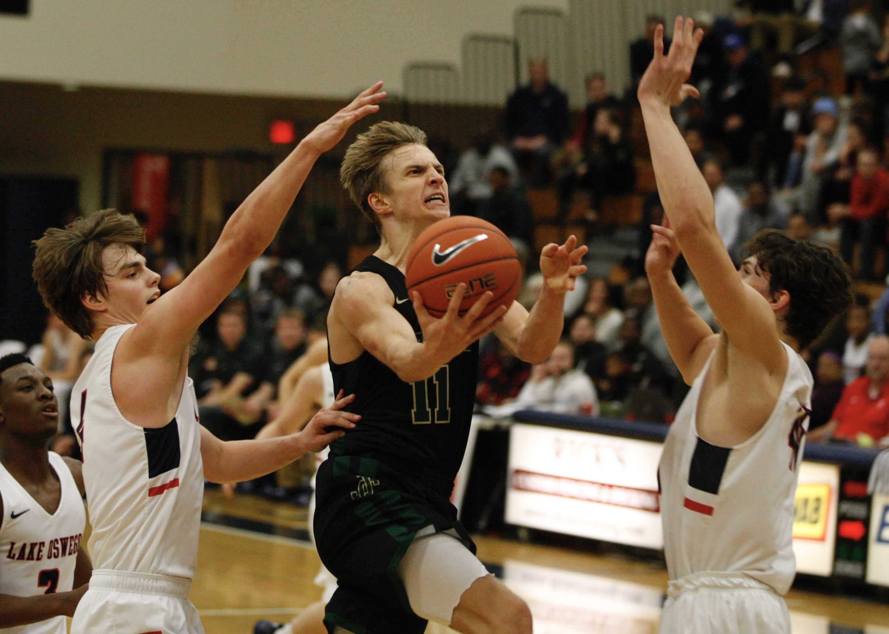 Jesuit's Will Sheaffer gets between Brandon Roberts (left) and Fred Harding IV of Lake Oswego for a crucial second-half layup.