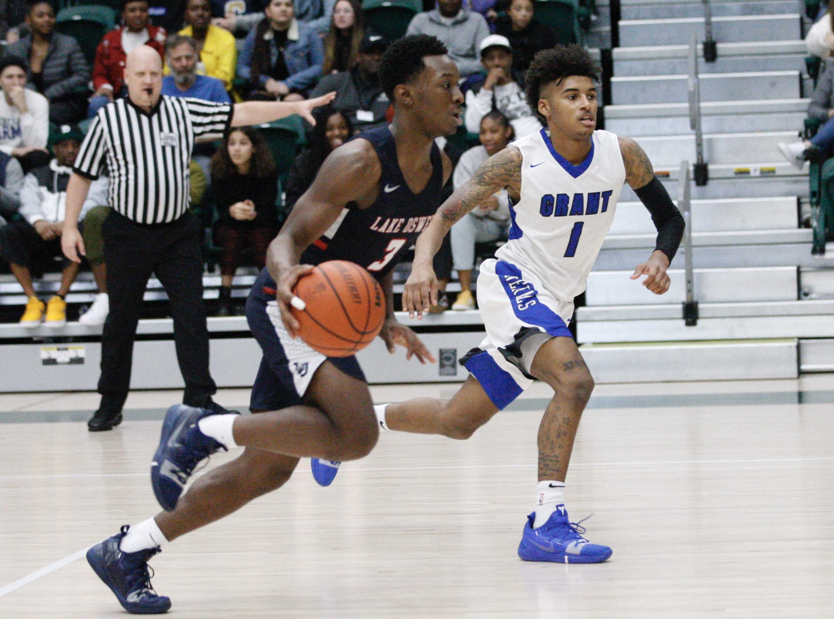 Lake Oswego guard Wayne McKinney blows past the defense of Grant's Aaron Deloney on his way to a 14-point night.