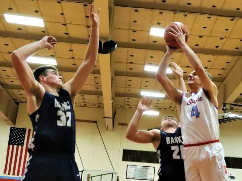 Seaside's Ryan Hague shoots against Banks' Blake Gobel (32) and Bret Cameron (21). (Photo by Jeff TerHar)