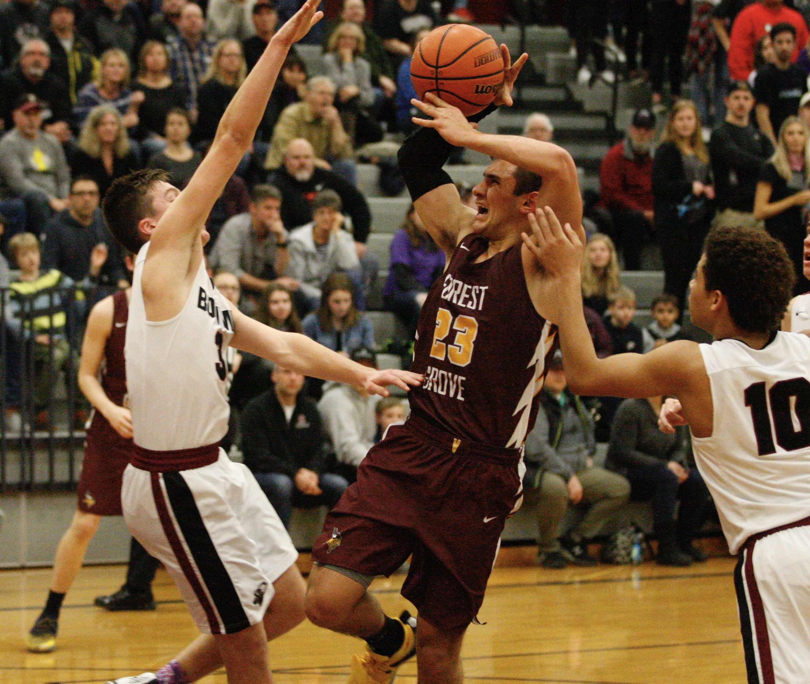 Sherwood defenders Tyler His (3) and Jamison Guerra reject a drive by Forest Grove's Guy Littlefield in decisive third quarter.