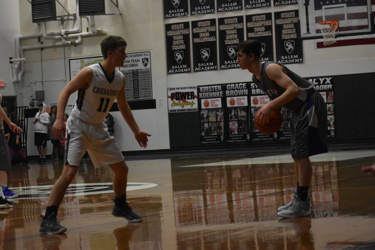 Salem Academy's Luke Miller (11) guards Amity's Michael Duncan on Wednesday night. (Photo by Jeremy McDonald)