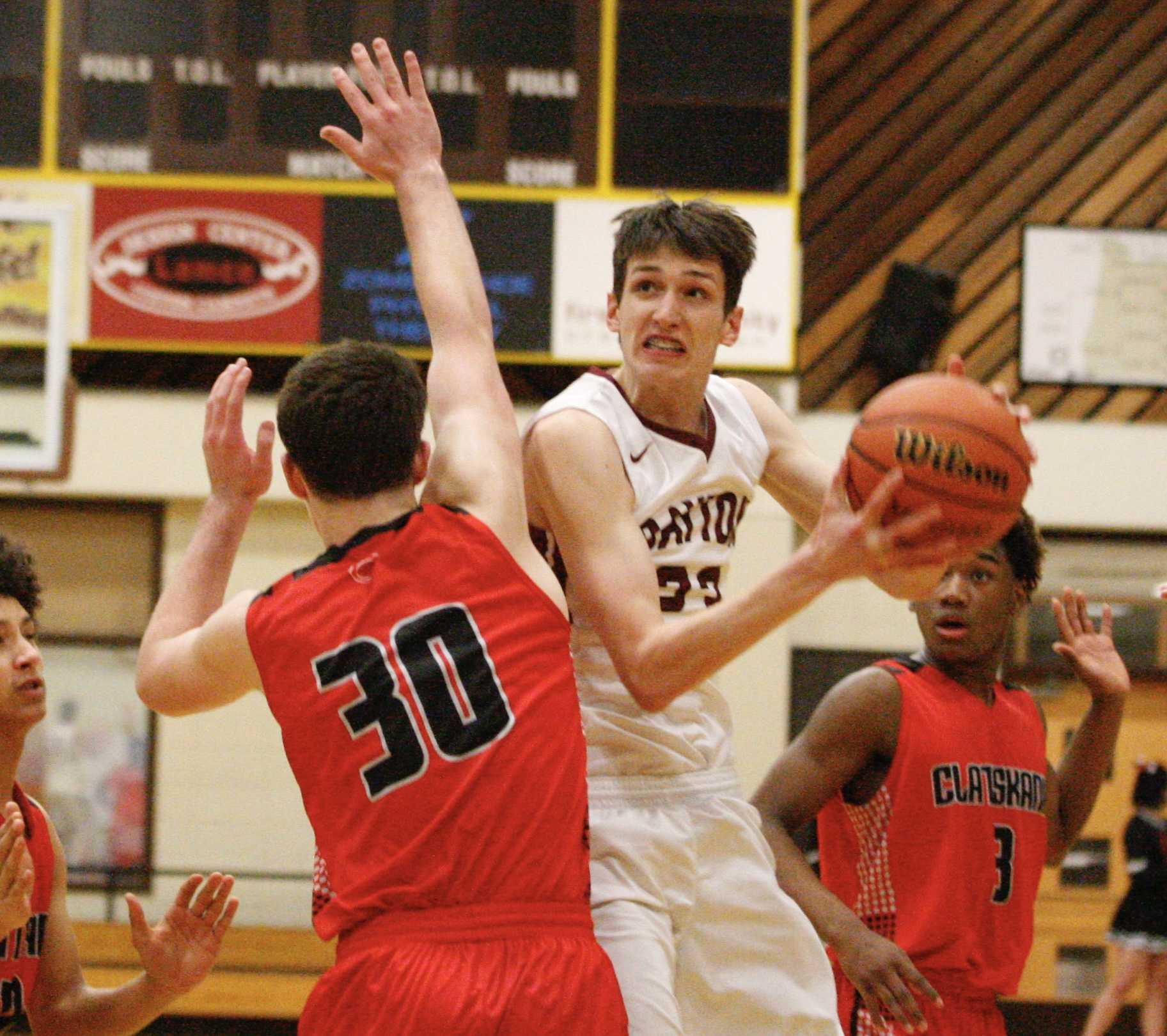 Dayton's Jaysen Howard gets between two Clatskanie defenders for a scoop shot Thursday. (Photo by Norm Maves Jr.)