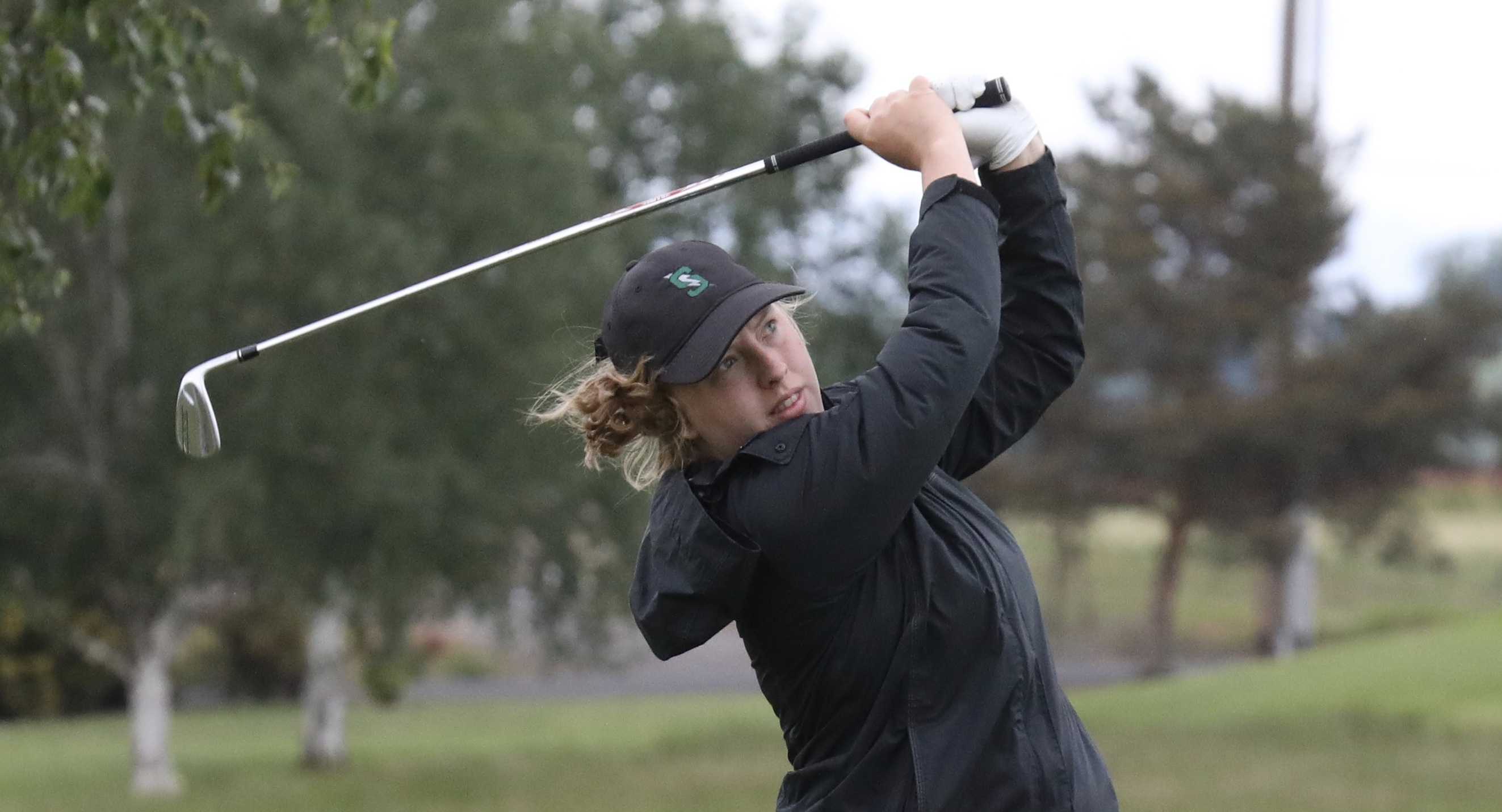 Summit's Olivia Loberg fires an iron shot into the 18th green at Quail Valley Golf Course. She won her third straight title